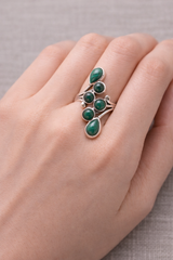 Bague en argent 925 ornée de malachites vertes, pierres rondes et en goutte, portée sur le dessus du doigt.