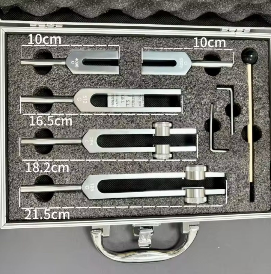 Set de 5 diapasons thérapeutiques avec boîtier contenant pièces métalliques et outils, indiquant mesures 10 cm, 16,5 cm, 18,2 cm et 21,5 cm.