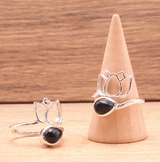 Bague Lotus Obsidienne et Argent 925 avec pierre noire en forme d’onyx, décor lotus ouvragé sur l’anneau et présentation conique bois, symbole d’ancrage et protection.