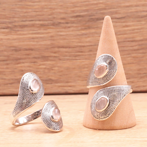 Bague Aura de Tendresse – Quartz Rose & Argent 925: ensemble de bijoux en argent 925 avec pierre d'un quartz rose sur bagues et pendentif sur socle en bois.