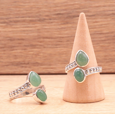 Bague Souffle de Renouveau – Aventurine verte et argent 925, devant un support en bois avec (3 bagues visibles) motifs argentés et pierres vertes.