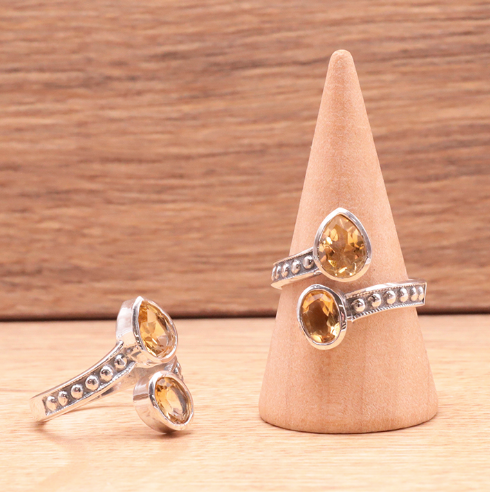 Bague Rayon Solaire - Citrine et Argent 925 avec pierres citrine ovales, montre des bijoux sur support bois, style anneaux ouverts et détails texturés.