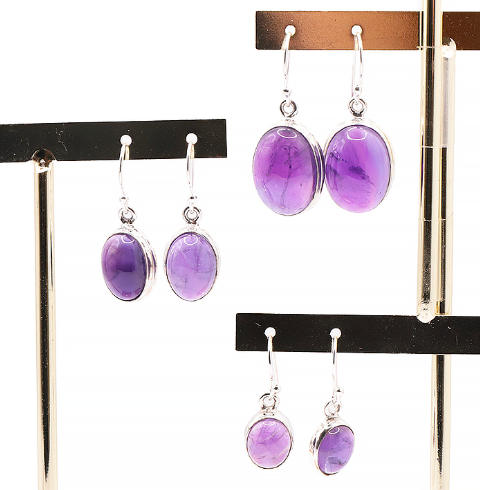 Boucles d’oreilles en argent 925 avec améthyste ovales violettes éclatantes, présentées sur support noir et doré.