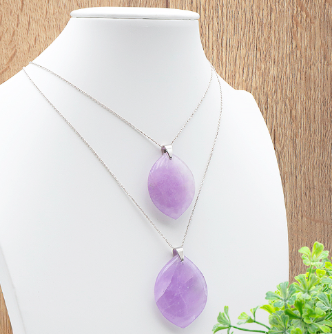 Pendentif Sérénis – Améthyste:  colliers avec pendentifs améthyste violets en pierre ovale sur chaîne argentée, drapés sur un présentoir blanc.