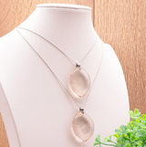 Pendentif Umbra – Cristal de Roche Fumé: deux pendentifs en quartz fumé transparents suspendus sur des chaînes argentées.