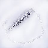 Bracelet argenté avec pendentif en forme de pendule ornementale, nommé Pendule de Thot, sur chaîne délicate.