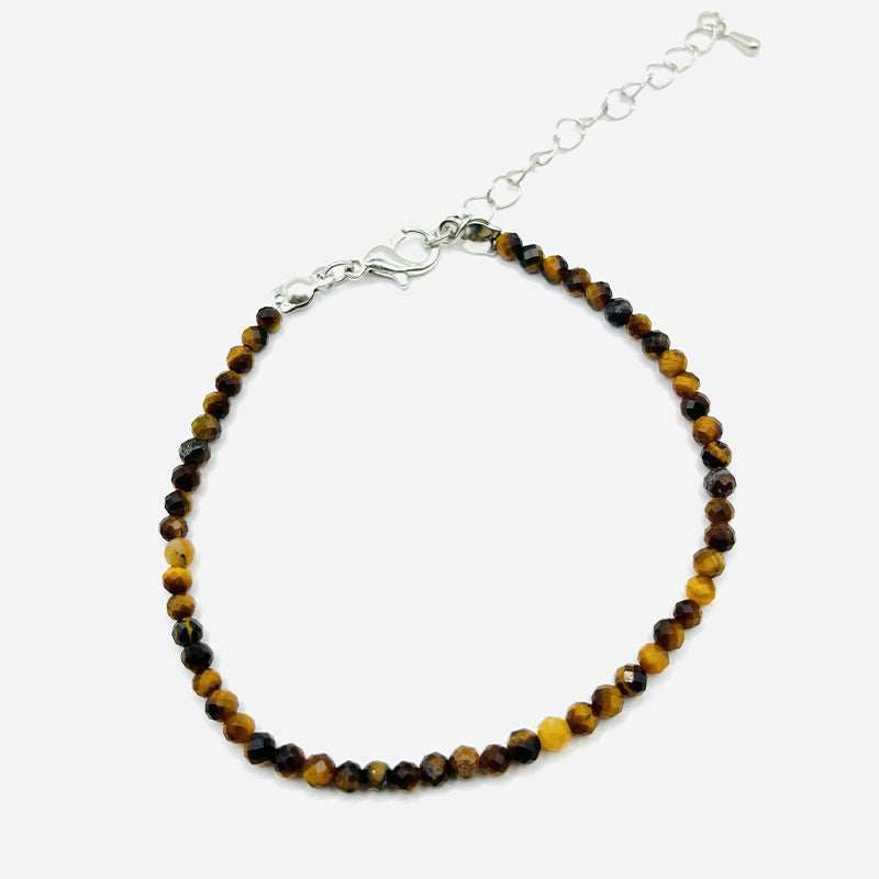 Bracelet fin de perles facettées œil de tigre dans des tons havane, avec chaîne d’extension argentée et fermoir. Bracelet Force Intérieure – Œil de Tigre Facetté.