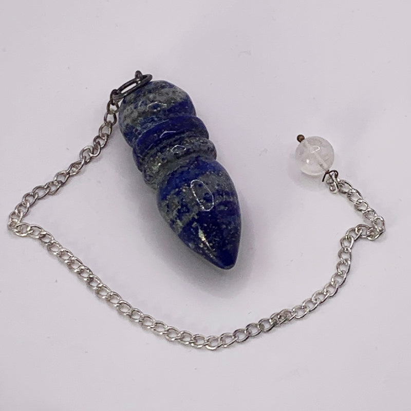 Pendule Egyptien en Lapis Lazuli, en forme de pointe, montée sur chaîne argentée avec perle claire à l’extrémité.